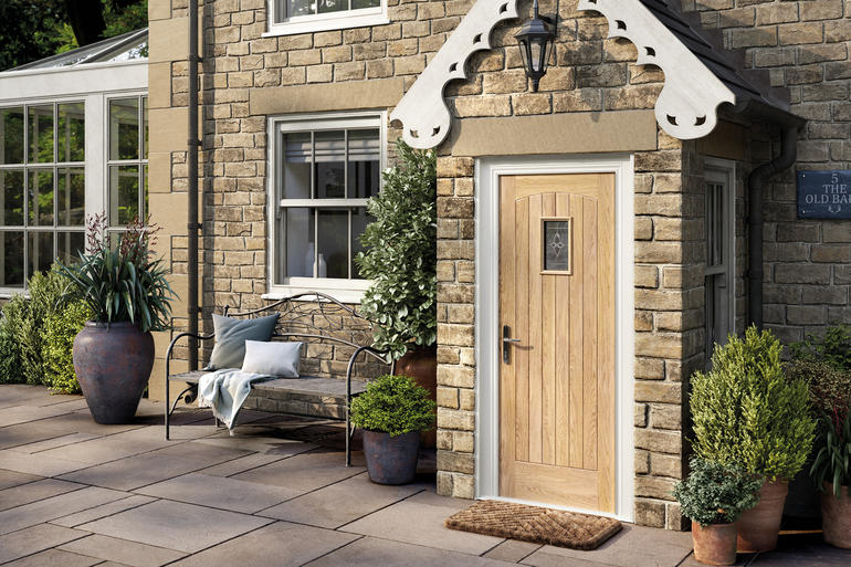 oak cottage style front door with a glazed section in a porch